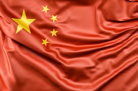 Bandera de China con fondo rojo y cinco estrellas amarillas en la parte superior izquierda, ondeando con textura de tela.